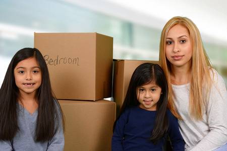 38730572-mother-and-her-two-young-daughters-packed-moving-boxes